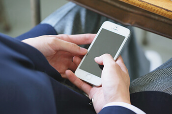 スマホいじる男子高校生イメージ