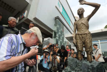 徴用工像の前で涙する原告