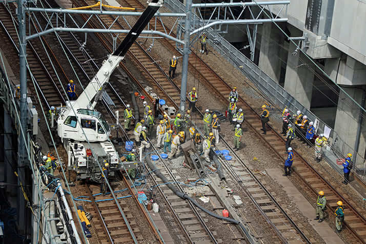 架線用の電柱をクレーン車で撤去しているところ