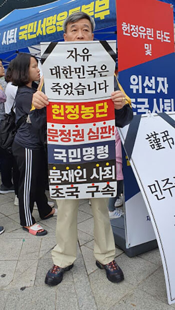 「自由な大韓民国は死んだ」という批判とともに文大統領退陣集会に参加した市民も