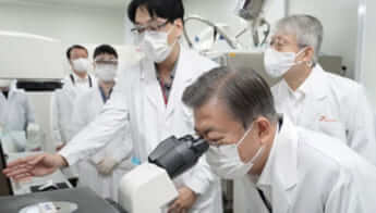 京畿道城南素材SKバイオサイエンス訪問し、細胞培養室で顕微鏡を覗く大統領