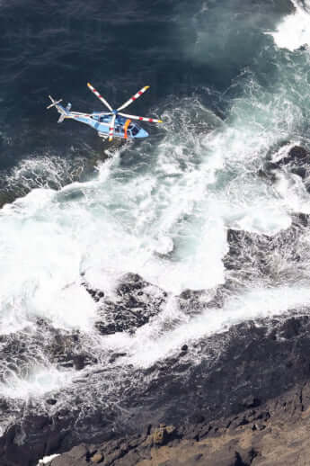 知床岬の海岸線を捜索する警察のヘリコプター