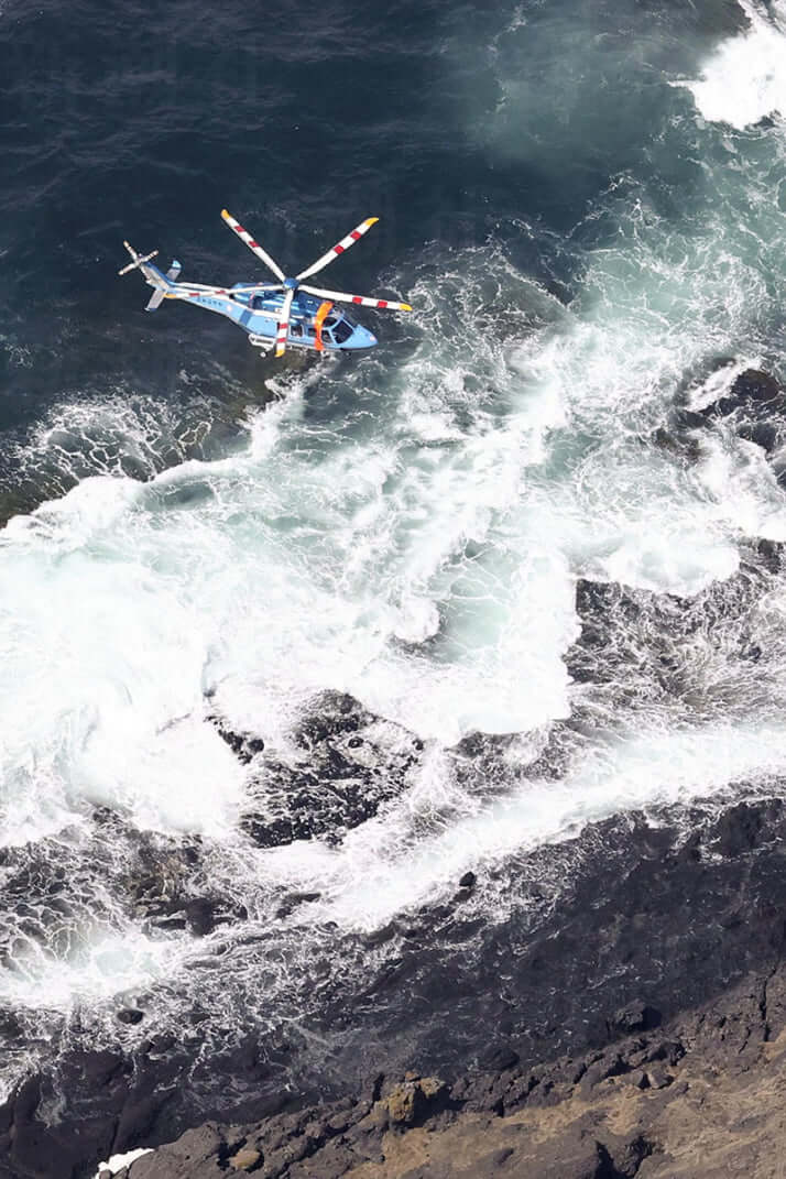 知床岬の海岸線を捜索する警察のヘリコプター