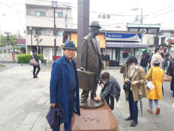 京成柴又駅前にある「フーテンの寅像」の隣に立つ筆者