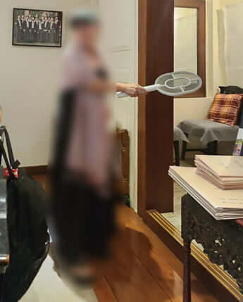 ラケット型の電撃殺虫器を持つHさん